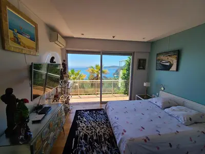 a bedroom with a bed and a view of the ocean at Eze sur mer - vue Saint Jean Cap Ferrat in Èze