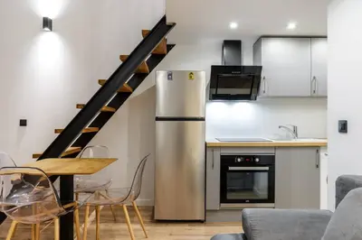 a kitchen with a stainless steel refrigerator and a table at Cocon au cœur du Vieux Nice in Nice