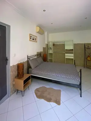 a bedroom with a large bed and a night stand at Villa Serenice - F2 au calme, climatisé, WIFI et parking gratuit in Nice