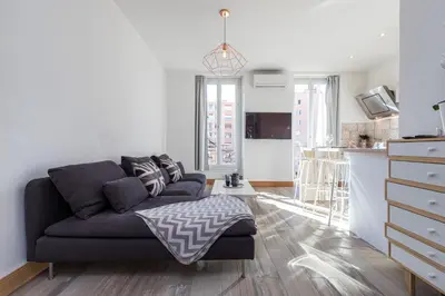 a living room with a couch and a kitchen at 253 MONT BORON - Appartement 2p - Balcon plein sud - Climatisation in Nice