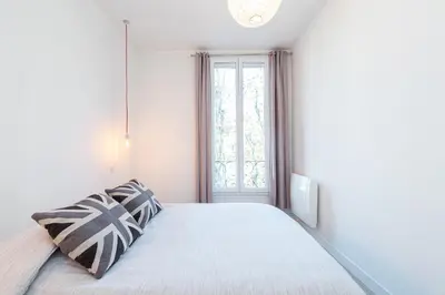 a white bedroom with a bed with a window at 253 MONT BORON - Appartement 2p - Balcon plein sud - Climatisation in Nice