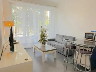a living room with a couch and a table at Charmant 2 pièces 600m plage 1km de la gare in Nice