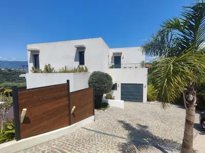 a white house with a wooden gate in front of it at VILLA MODERNE PISCINE JACUZZi in Nice
