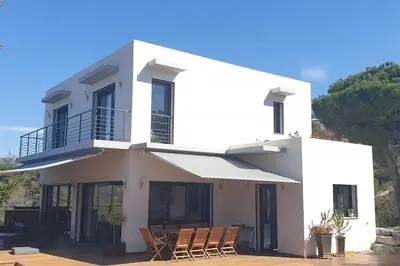 a white house with chairs in front of it at VILLA MODERNE PISCINE JACUZZi in Nice