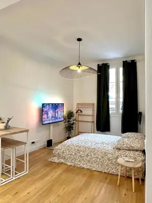 a bedroom with a bed and a desk and a television at Studio Cosy à Nice Centre in Nice