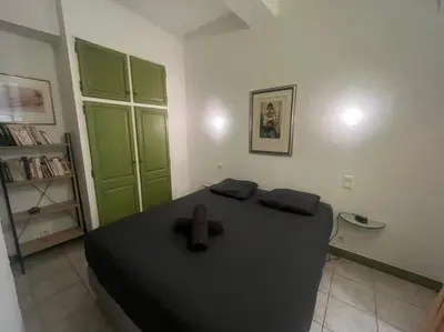 a bedroom with a black bed and green cabinets at Centrale - Grand T2 Bis proche de la mer in Nice