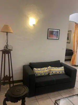a living room with a black couch and a lamp at Centrale - Grand T2 Bis proche de la mer in Nice