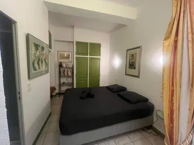 a bedroom with a bed with a green door at Centrale - Grand T2 Bis proche de la mer in Nice