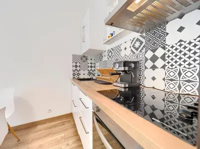 a kitchen with black and white tiles on the wall at CENTRE VILLE - SUPERBE APPARTEMENT CLIMATISE - COSY-Wifi - in Nice