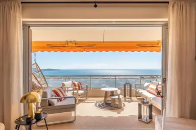 a room with a balcony with a view of the ocean at Les Belles Terres - Résidence avec piscine vue mer in Nice