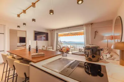 a kitchen with a table and a dining room at Les Belles Terres - Résidence avec piscine vue mer in Nice