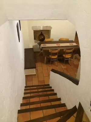 a staircase leading to a kitchen with a table and chairs at Maison de caractère in Saint-Jeannet