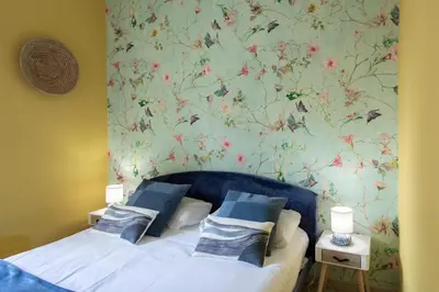 two beds in a bedroom with a floral wallpaper at #13 Orange suite AC Wifi Balcony 3mins walk sea front in Nice