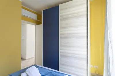 a bedroom with a blue accent wall and a closet at #13 Orange suite AC Wifi Balcony 3mins walk sea front in Nice