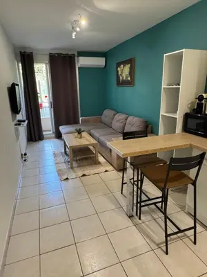 a living room with a couch and a table at Logement proche de la plage in Nice