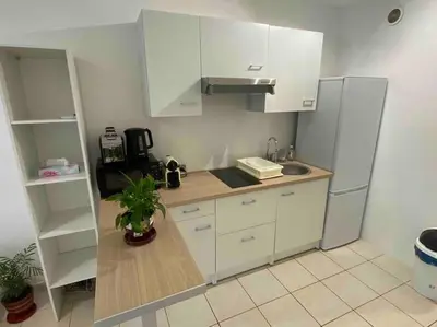 a kitchen with white cabinets and a refrigerator at Logement proche de la plage in Nice