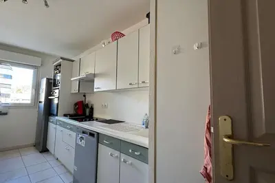 a kitchen with white cabinets and a stove top oven at Nice Proche Mer in Nice