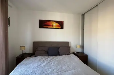 a bedroom with a bed and two night stands with lamps at Nice Proche Mer in Nice