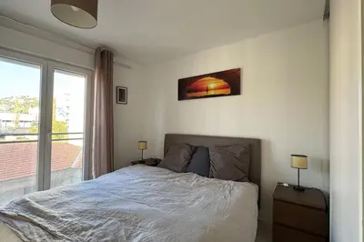 a bedroom with a bed and a large window at Nice Proche Mer in Nice