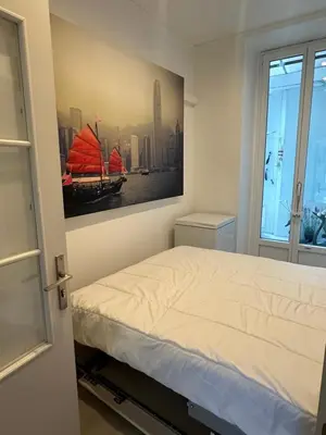 a bedroom with a bed with a painting on the wall at PORT CARNOT AP4405 By Riviera Holiday Homes in Nice