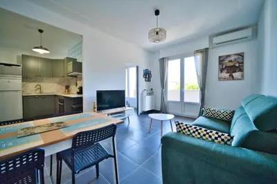 a kitchen and a living room with a couch and a table at oliveraie in Nice