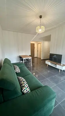 a green couch in a living room with a table at oliveraie in Nice