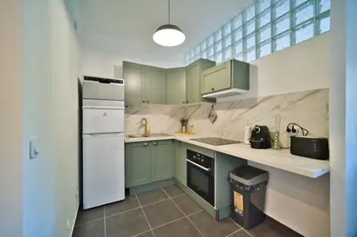 a kitchen with green cabinets and a white refrigerator at oliveraie in Nice