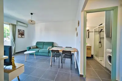 a living room with a couch and a table and chairs at oliveraie in Nice