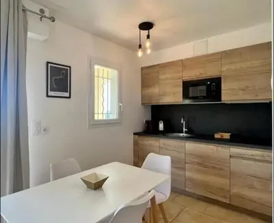 a kitchen with a white table and white chairs at DOMAINE LOU BEL AZUR - Elégant in Saint-Laurent-du-Var