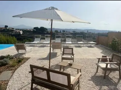 a group of chairs and an umbrella next to a pool at DOMAINE LOU BEL AZUR - Elégant in Saint-Laurent-du-Var