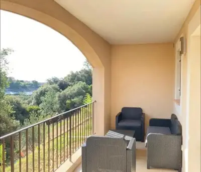 a porch with two chairs and a balcony with a view at DOMAINE LOU BEL AZUR - Elégant in Saint-Laurent-du-Var