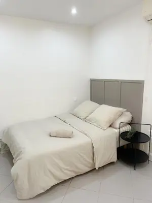 a white bedroom with a large bed and a table at République in Nice