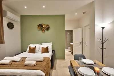 a bedroom with a large bed and a dining room at Cosy Apparts Hypercentre de Nice in Nice