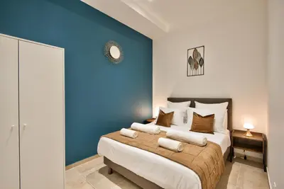 a bedroom with a large bed with a blue wall at Cosy Apparts Hypercentre de Nice in Nice