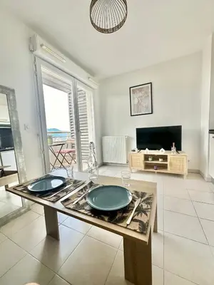 a living room with a table with two plates on it at Cosy studio avec parking et vue féerique in Nice