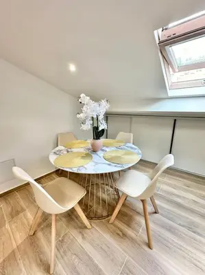 a table with chairs and a vase of flowers on it at Appartement climatisé - 2min plage-tram-restaurant in Nice