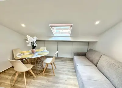 a living room with a couch and a table at Appartement climatisé - 2min plage-tram-restaurant in Nice