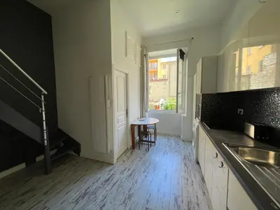 an empty kitchen with a table and a window at Malyandco in Nice