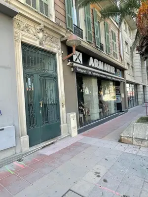 a store front with a green door on a street at Malyandco in Nice