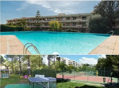 a large swimming pool in front of a building at Studio piscine climatisation tennis in Nice