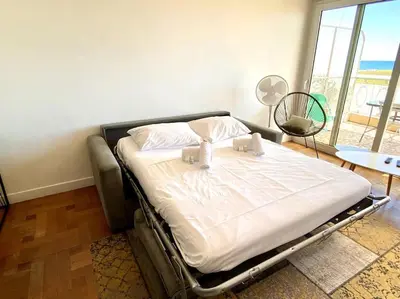a large bed in a room with a large window at Large flat terrace Sea view, Promenade des Anglais in Nice