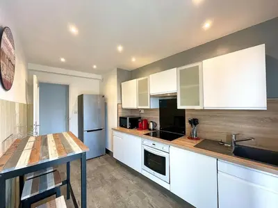 a kitchen with white cabinets and a counter top at Large flat terrace Sea view, Promenade des Anglais in Nice