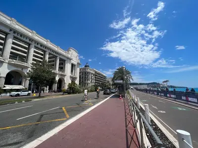 a city street with people riding bikes on a sidewalk at Studio Palais de la Méditerranée in Nice