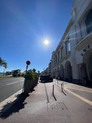 a street with a row of benches next to a building at Studio Palais de la Méditerranée in Nice