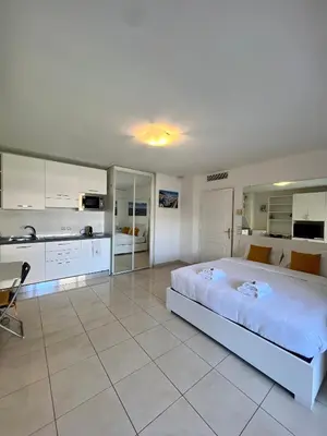a large bedroom with a large bed and a kitchen at Studio Palais de la Méditerranée in Nice