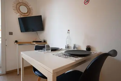 a white table with two chairs and a tv at Cocon Urbain - Près de la Gare in Nice