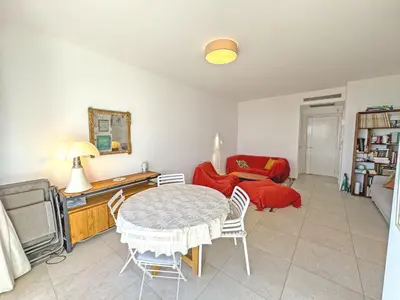 a living room with a table and a couch at Cosy Sea Front Garden Nice in Nice