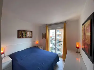 a bedroom with a blue bed and a window at Nice Magnan 2P-Piscine, Clim, Parking in Nice