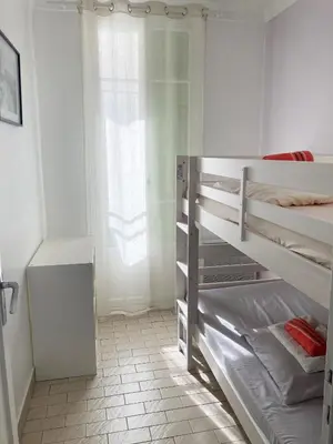 a white bedroom with a bunk bed and a window at À 2 pas du centre in Nice