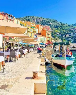 a harbor with a boat in the water and buildings at À 2 pas du centre in Nice
